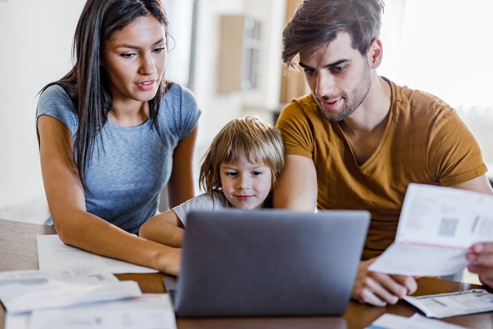 Parents and child look at laptop and statement