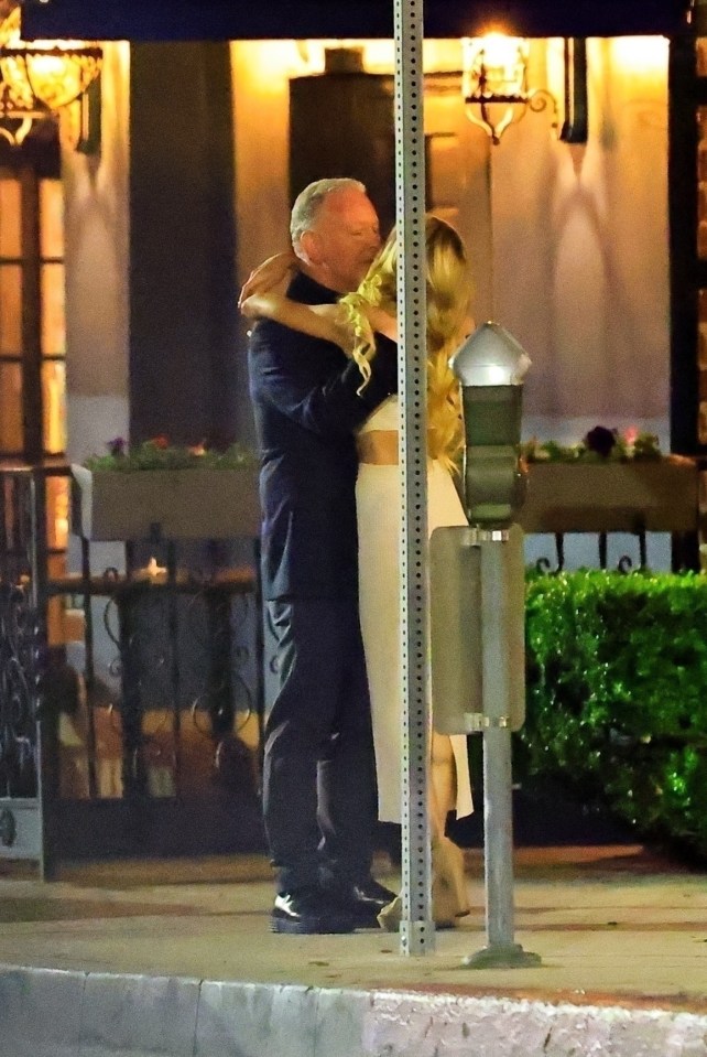 Paul Kemsley embracing a woman outside a restaurant.