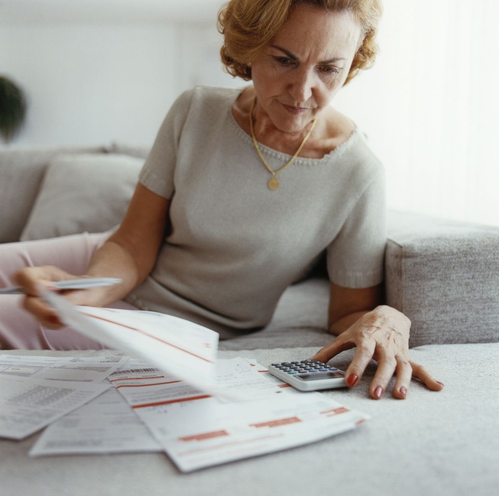 Pensioner looks at documents and calculator