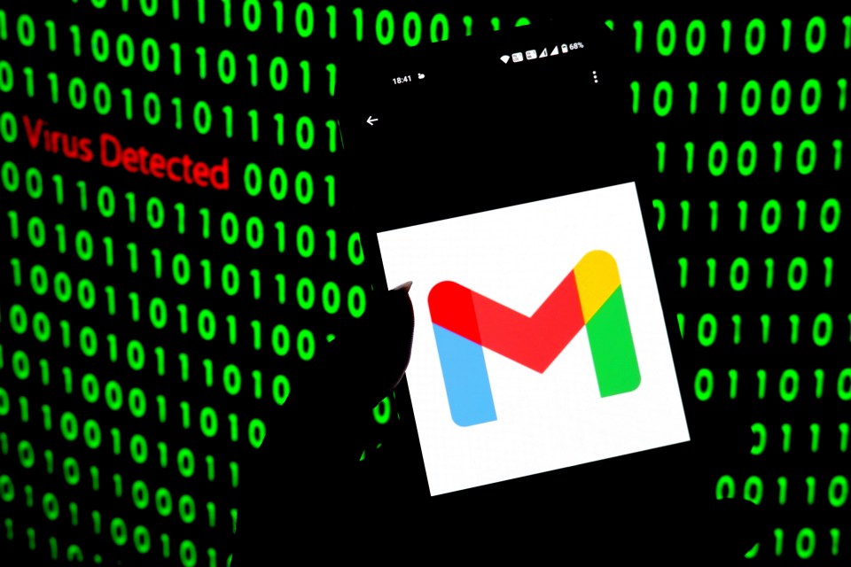 Photo illustration of Gmail logo on a smartphone screen with a "Virus Detected" message and binary code in the background.