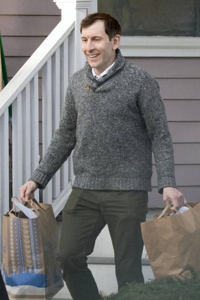 Erik Per Sullivan carrying coffee and bags.