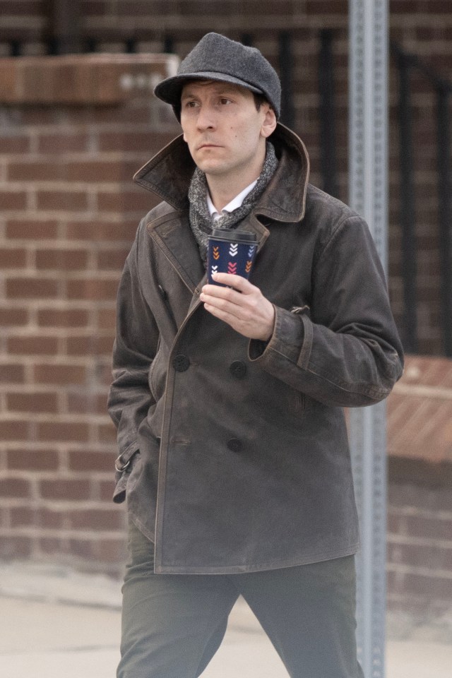 Erik Per Sullivan carrying a coffee cup.