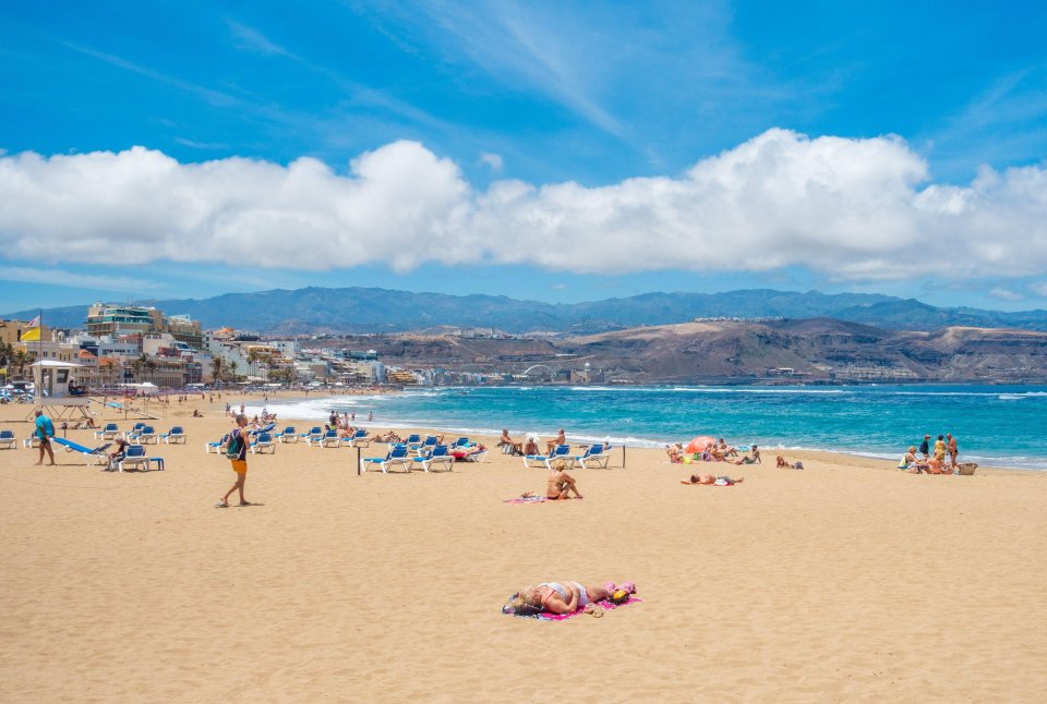 Tourists sunbathing on a beach in Las Palmas, Gran Canaria.