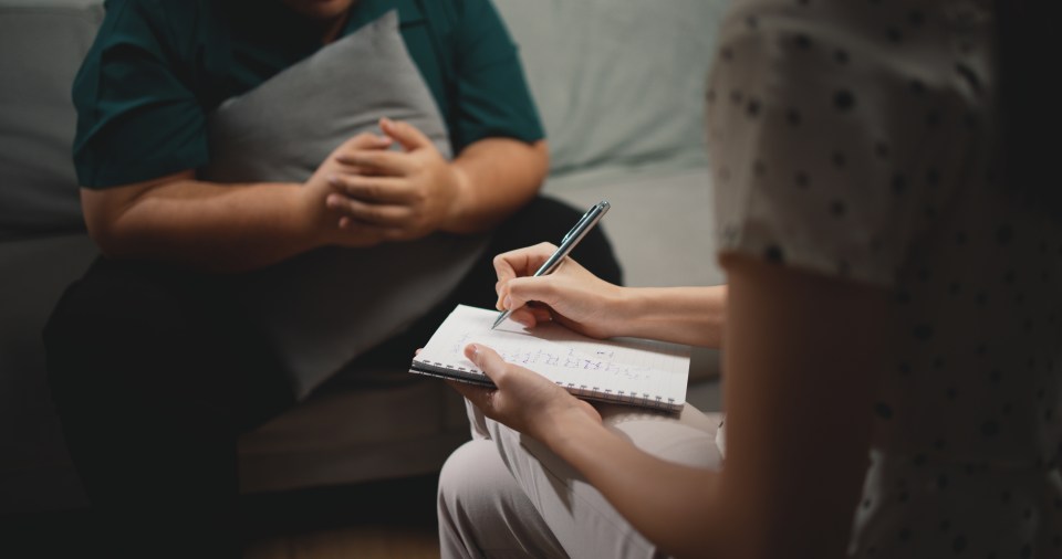 Therapist taking notes during a therapy session.