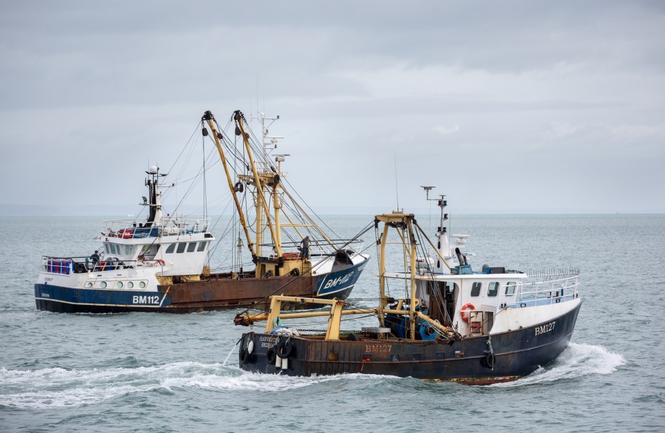 Two fishing trawlers at sea.