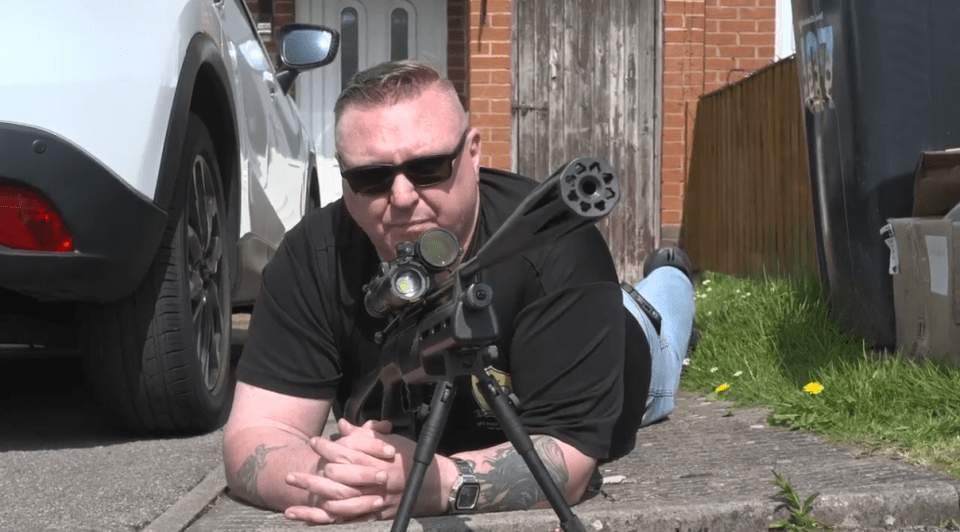 Rat catcher lying on the ground with a rifle.