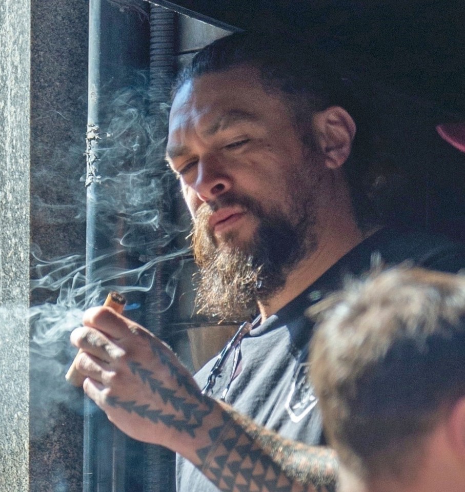 Jason Momoa smoking a cigar.