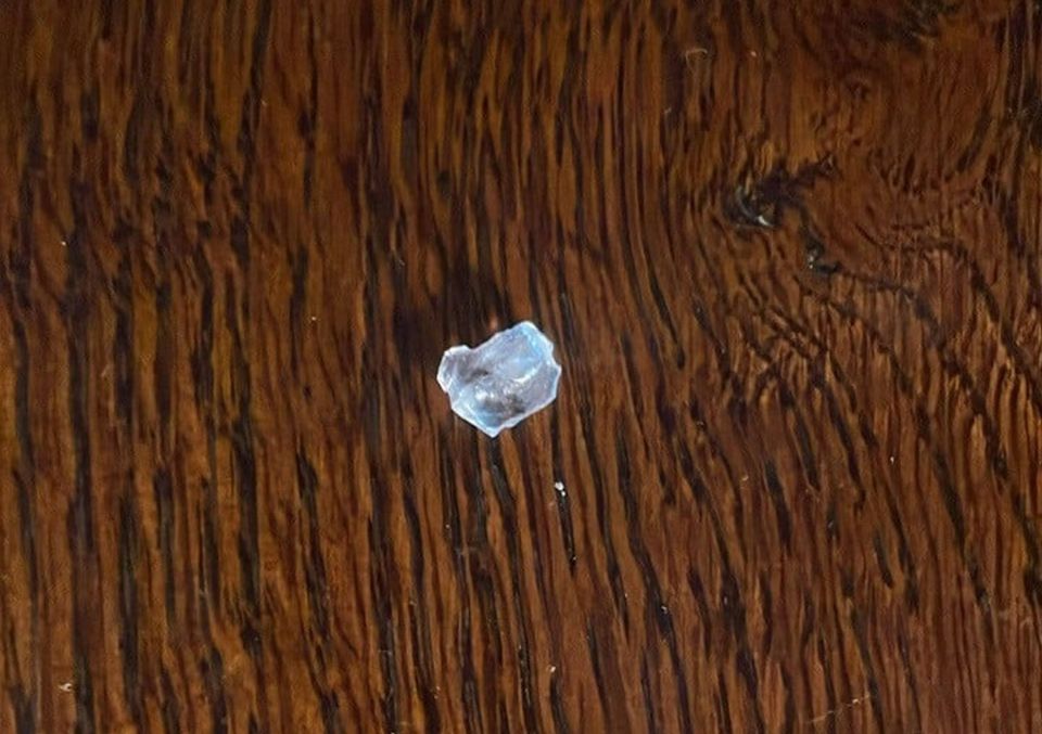 Piece of glass on a dark wooden surface.
