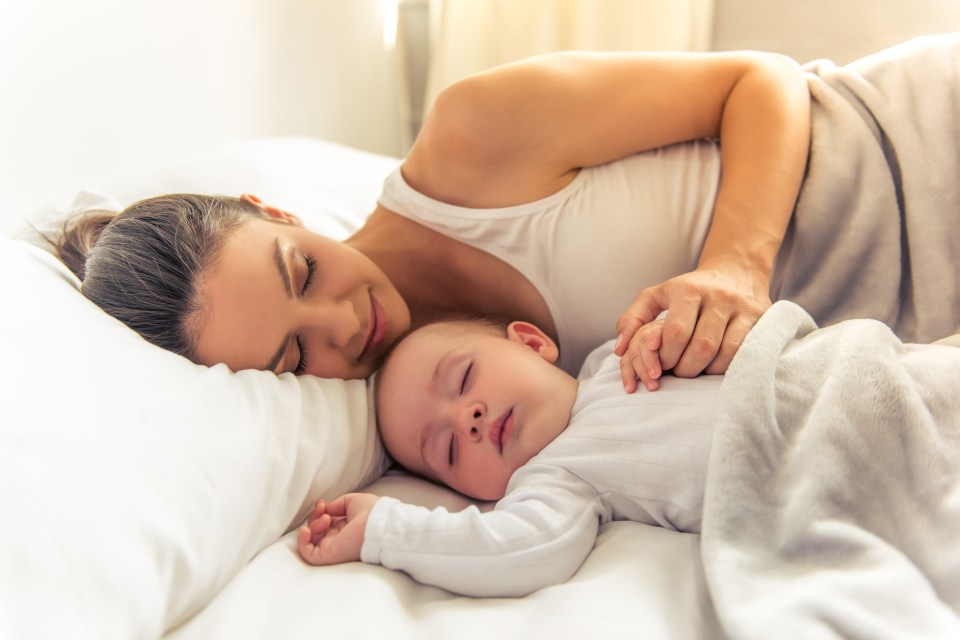 Mother and baby sleeping in bed.
