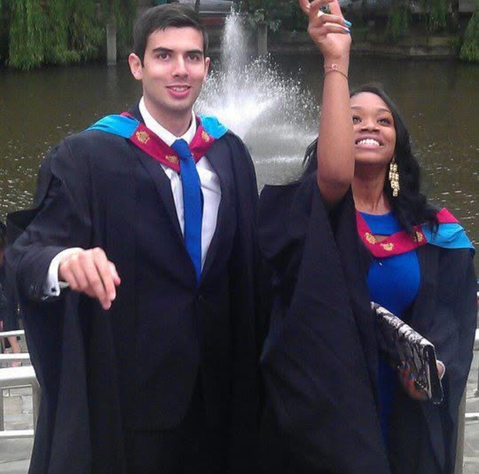 Two graduates in graduation gowns.