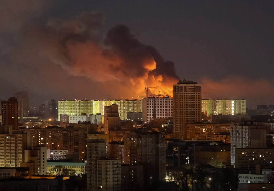 Smoke rises over a city at night after a drone strike.