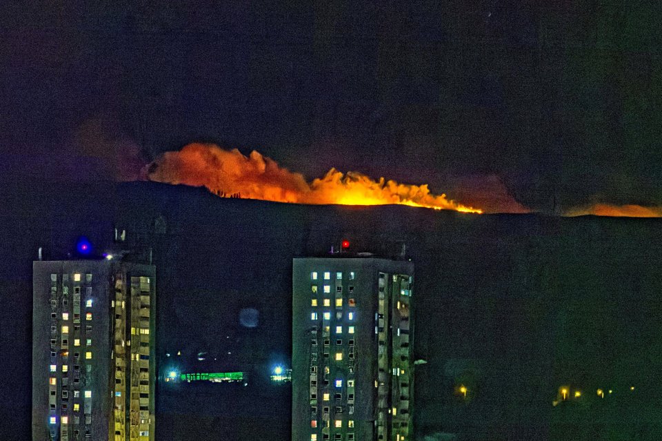 Nighttime wildfire in the hills above Glasgow, Scotland, seen from nearby apartment buildings.