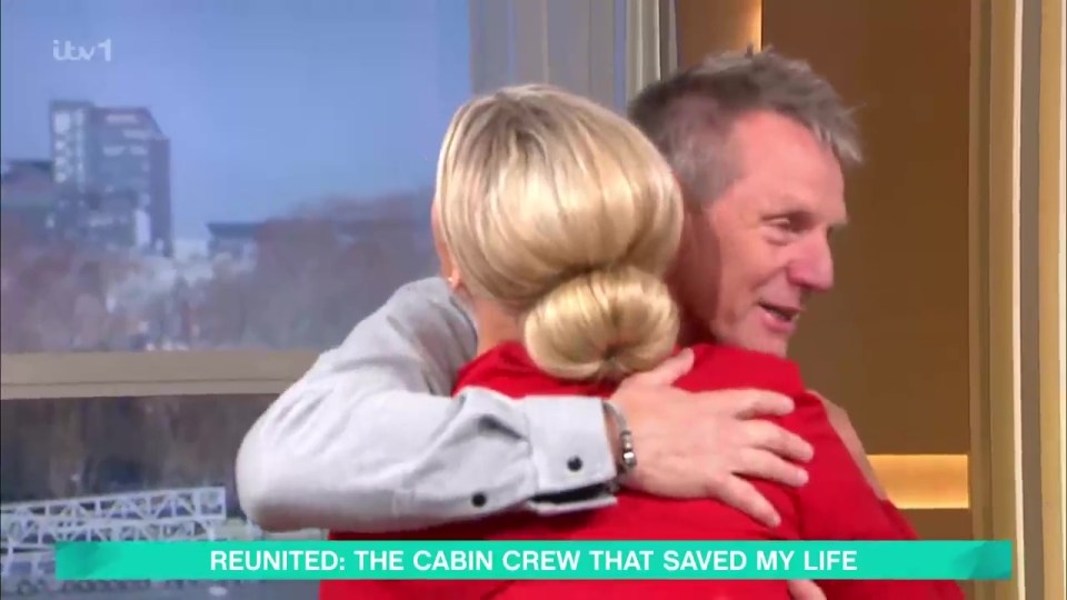 Stuart Pearce hugging a woman, reunited with the cabin crew that saved his life.