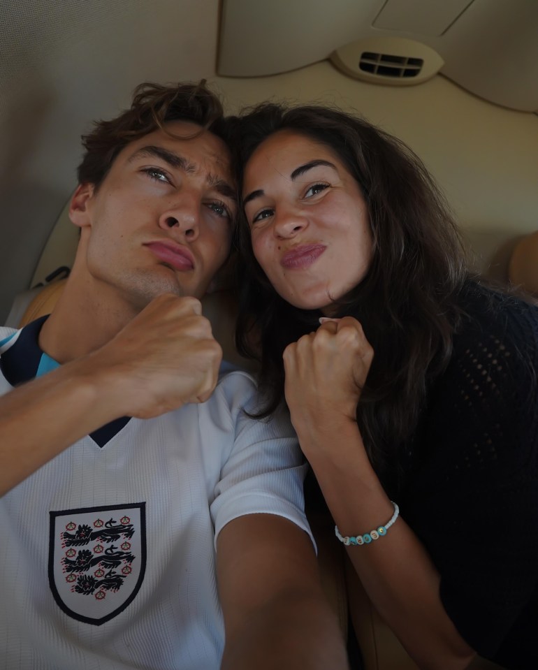 Selfie of a young couple making fists, the man wearing an England football jersey.