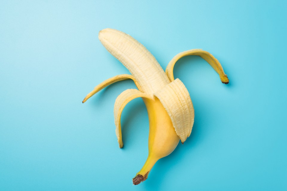 Peeled banana on a blue background.