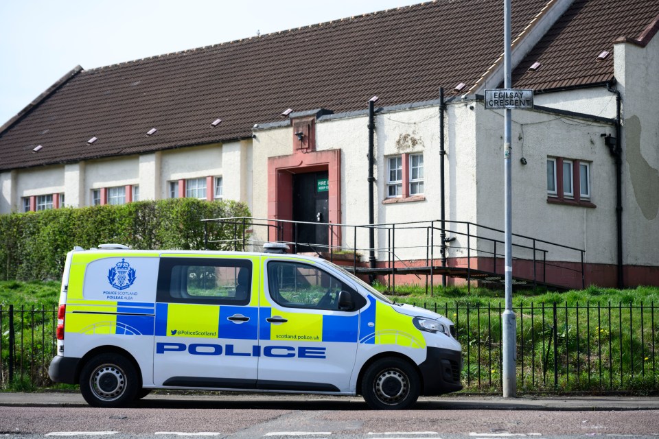 Police van parked outside a building following a stabbing incident.