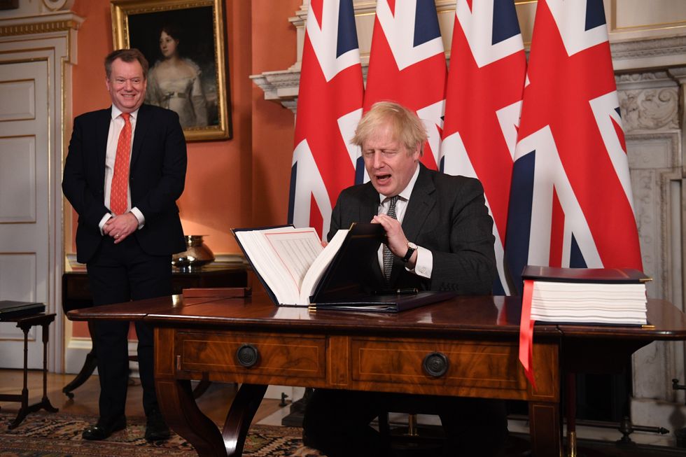 UK chief trade negotiator, David Frost, looks on as Prime Minister Boris Johnson signs the EU-UK Trade and Cooperation Agreement