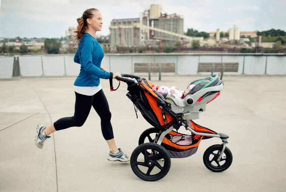 Woman jogging with a baby in a stroller.