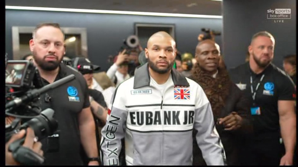 Chris Eubank Jr. walking with security.