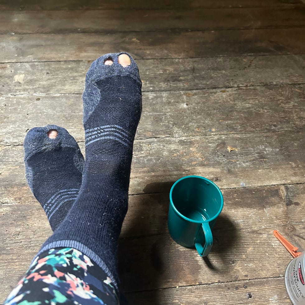 lady sitting on the floor during her walking trip with hole in sock