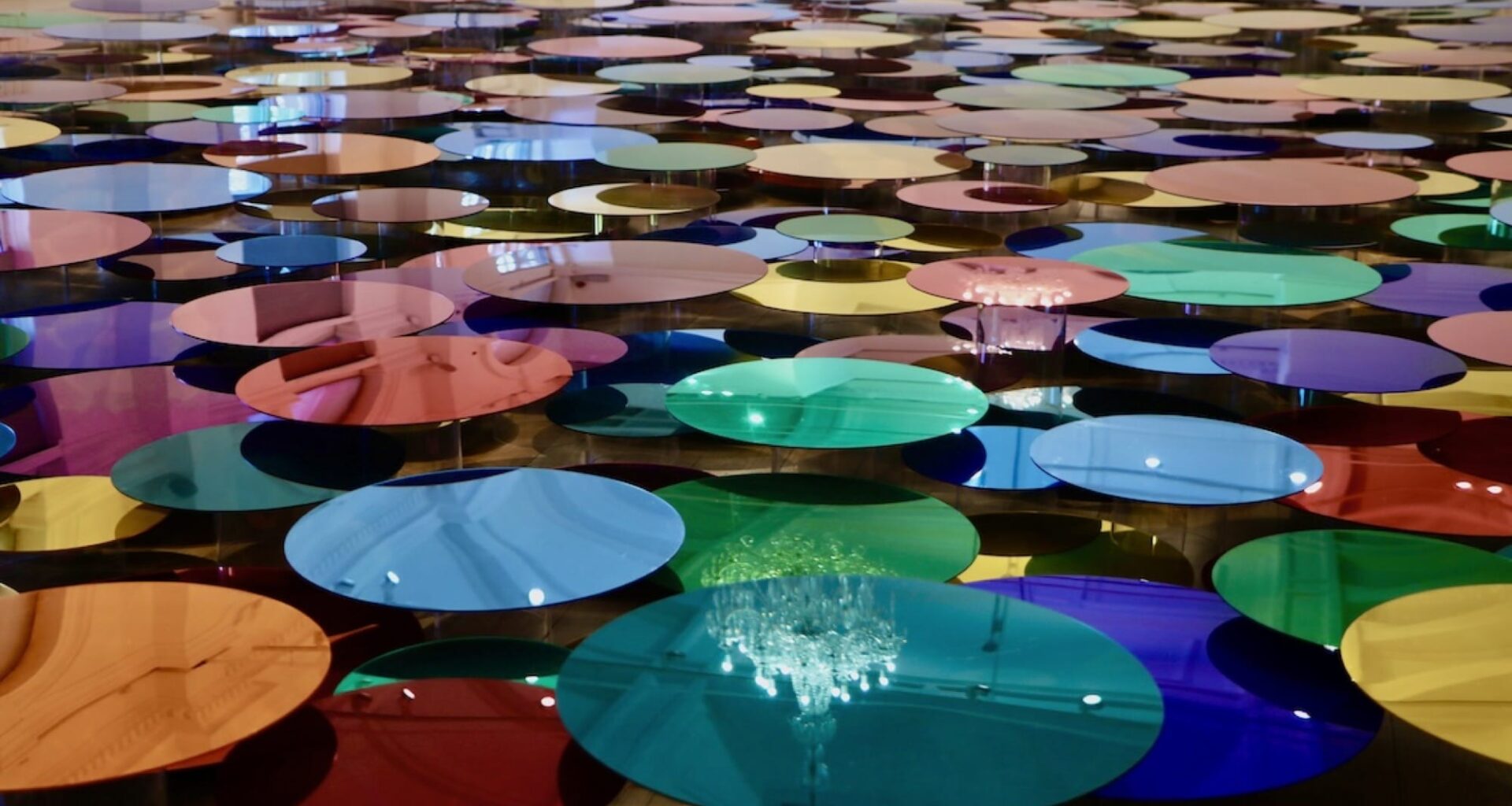 a floor installation of numerous shiny, colorful circles