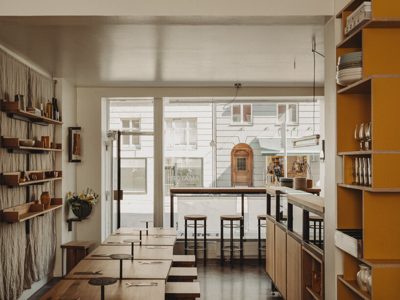 wiercinski-studio builds cozy 'amator' restaurant around modular oak table in copenhagen
