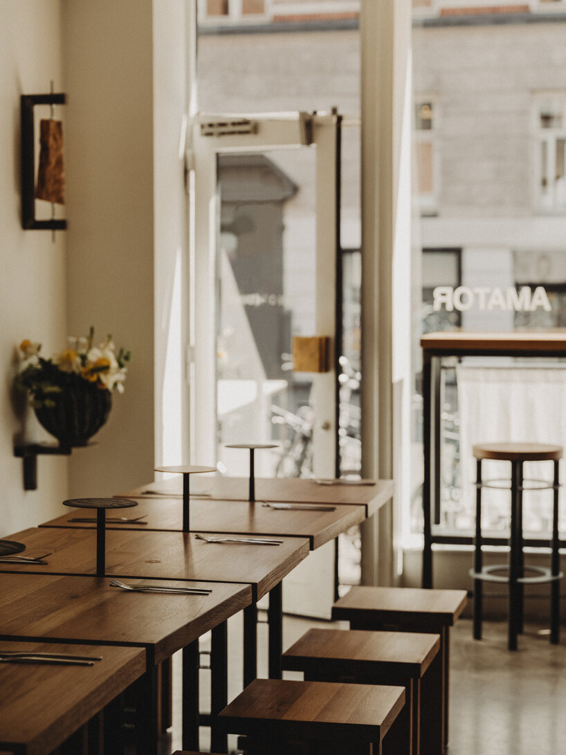 wiercinski-studio builds cozy 'amator' restaurant around modular oak table in copenhagen