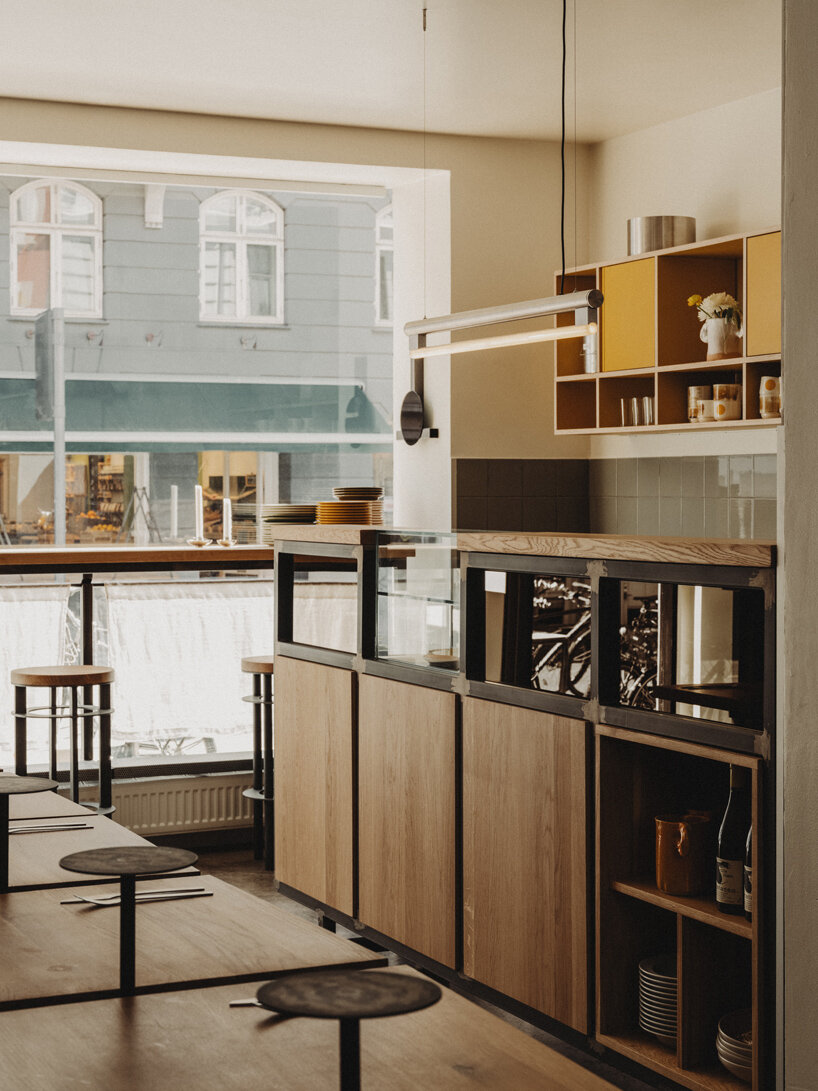 wiercinski-studio builds cozy 'amator' restaurant around modular oak table in copenhagen