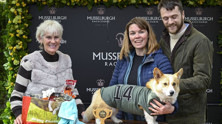 Winner of the Corgi Derby, Juno with his owners Fran Brandon and Alisdair Tew, is presented a trophy.
