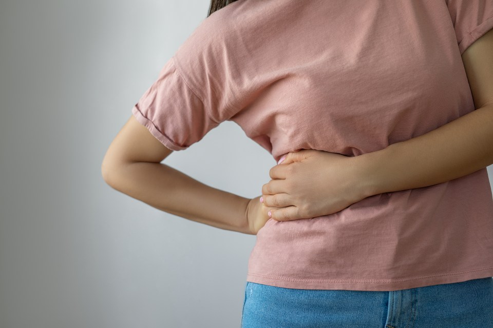 Woman holding her side in pain.