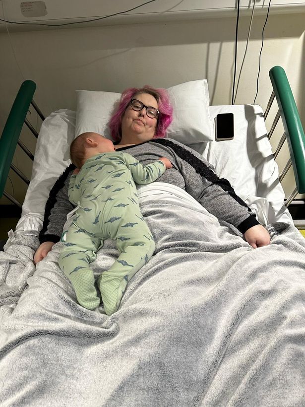 Woman in hospital bed with baby.