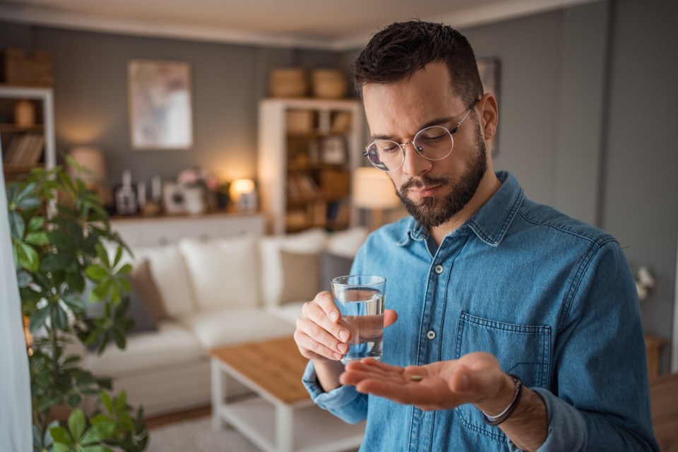 Man taking medication with water.