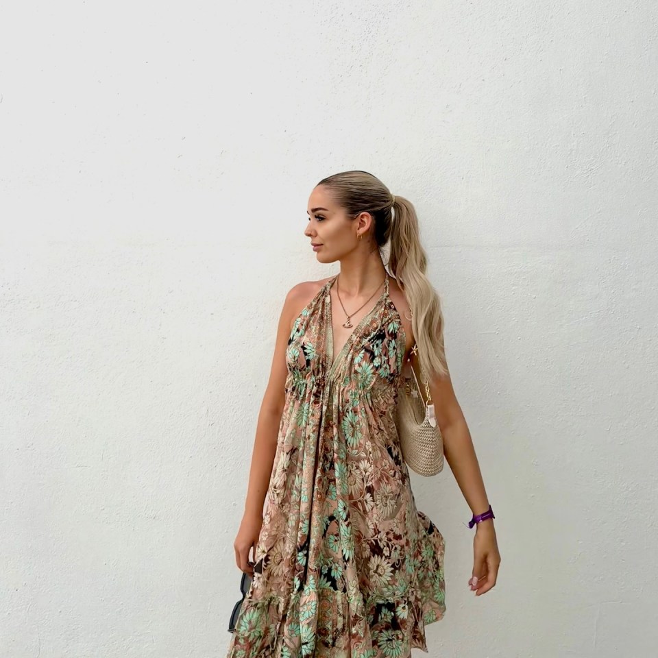Woman in floral dress and handbag.