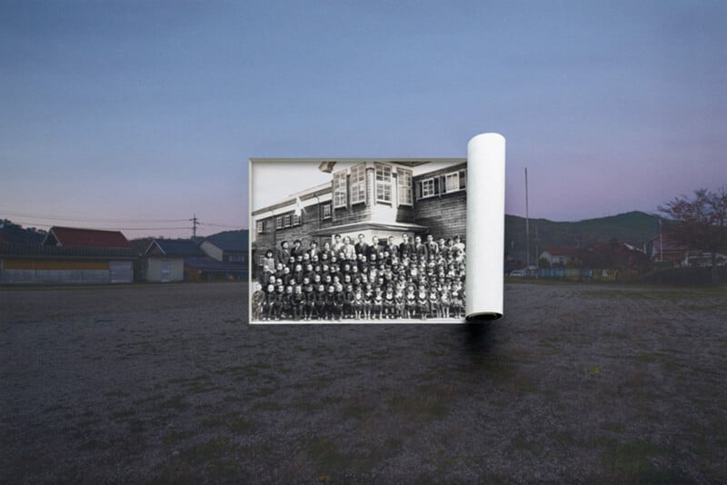 A group black-and-white photo unrolls like a scroll, floating in front of a modern, empty outdoor landscape at dusk with houses, hills, and a wide gravel ground in the background.