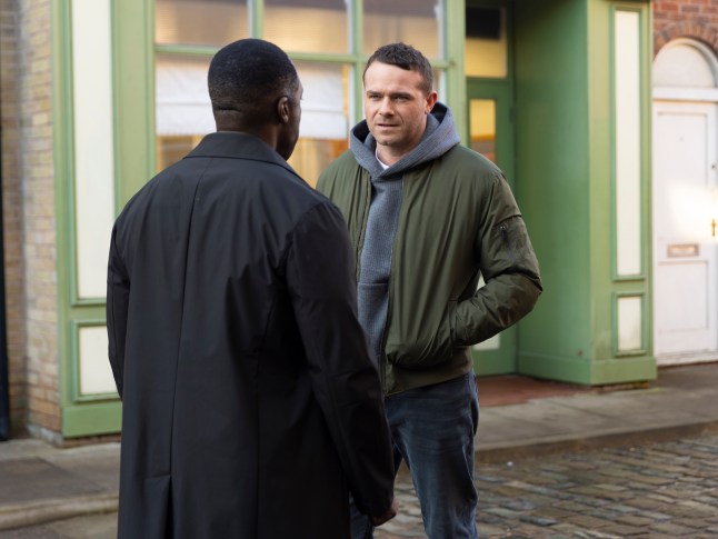 Mick stands opposite Ronnie with his hands in his pockets in Coronation Street