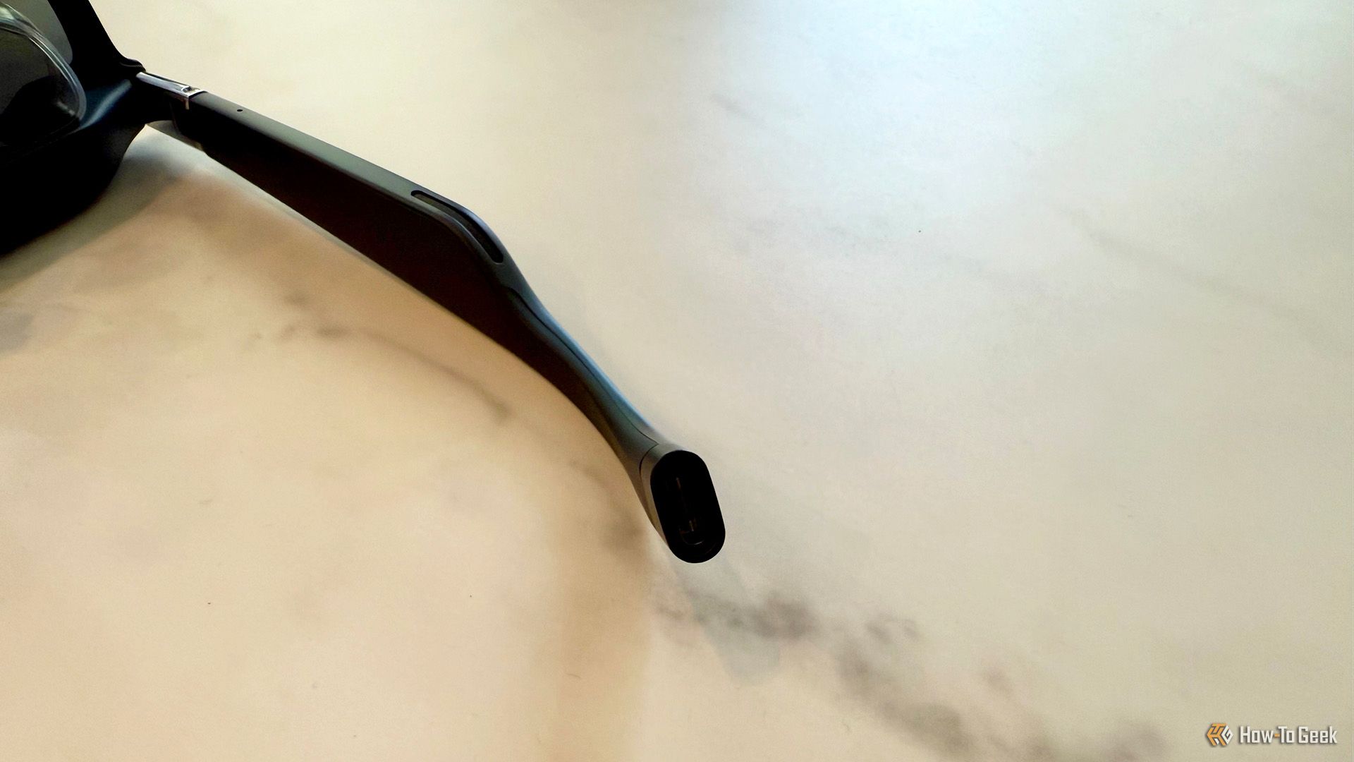A close-up of the USB-C port on the temple of the XREAL One AR Glasses.