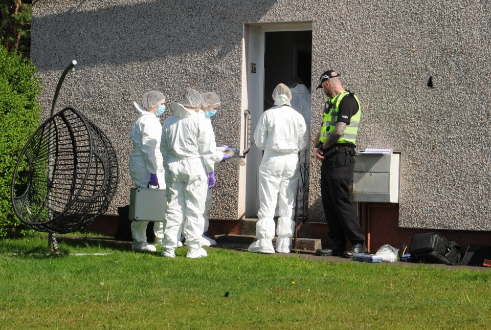 Forensic investigators and a police officer at a crime scene.