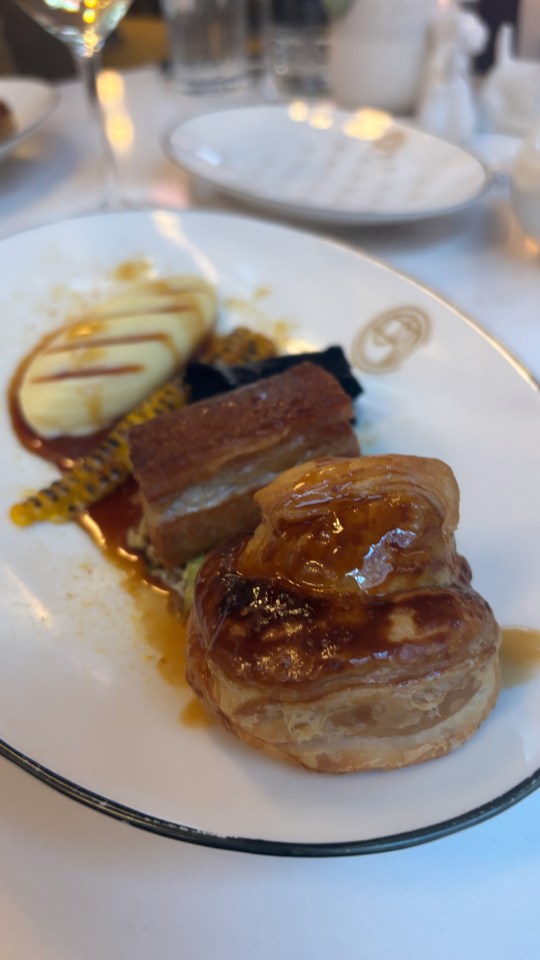 Roast pork belly with mashed potatoes and pastry on a plate.