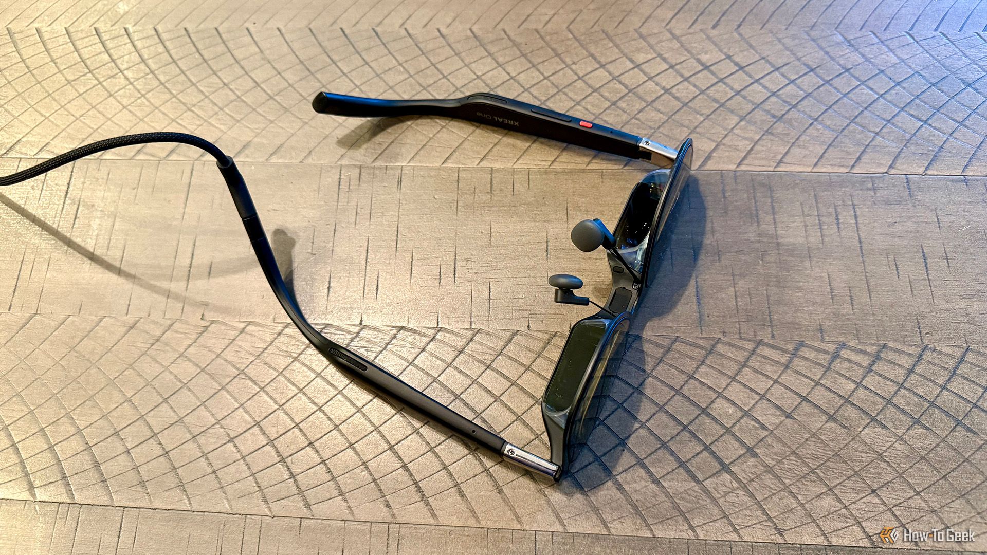 Angled overhead view of the underside of the XREAL One AR Glasses on a table.