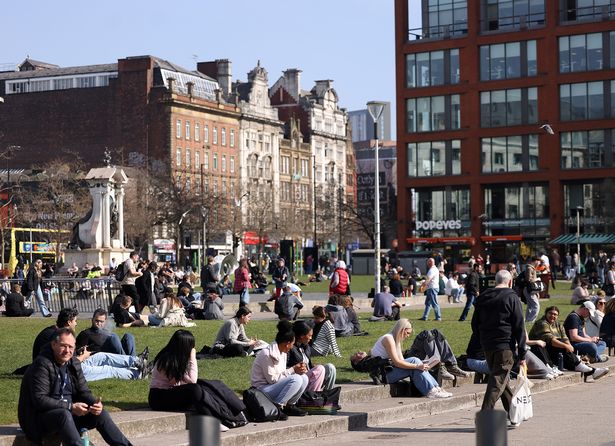 People enjoy the sun in Manchester's Piccadilly Gardens 