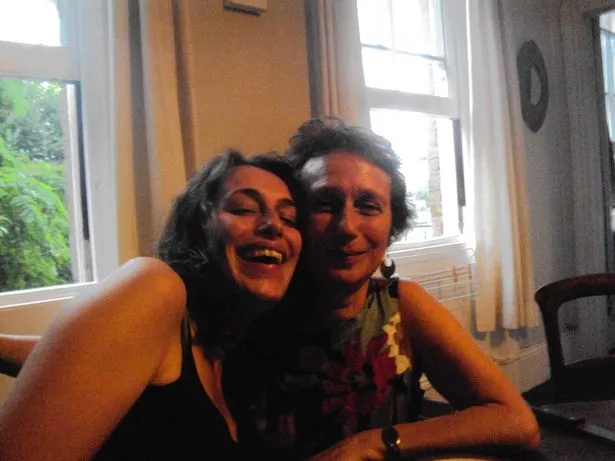 Anna and her mother sitting close together to take a photo