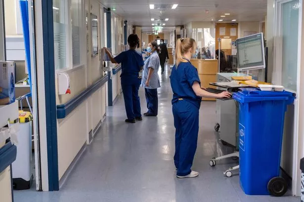 File photo dated 18/01/23 of a general view of staff on a NHS hospital ward. It is a corridor with NHS clinical staff, waste bins, and clinical areas. 