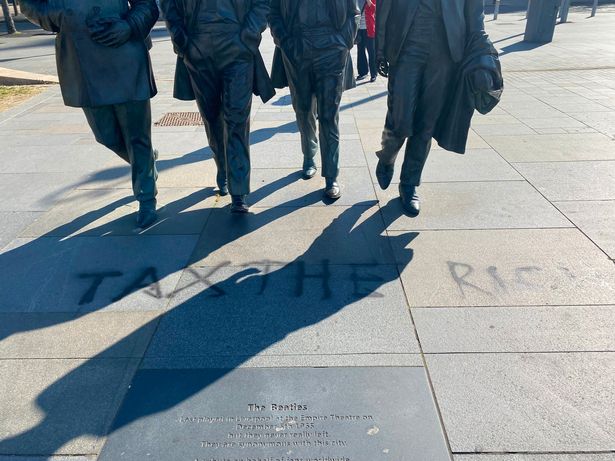 'Tax the rich' has been written on the floor at The Beatles statue on Liverpool's Pier Head