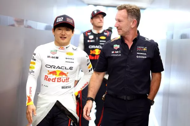 Christian Horner and Yuki Tsunoda in conversation as they walk into the Red Bull garage