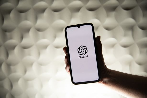 A person holds a telephone displaying OpenAI s ChatGPT artificial intelligence logo in front of a white lit background in Kerlouan in Brittany in France on February 26 2025