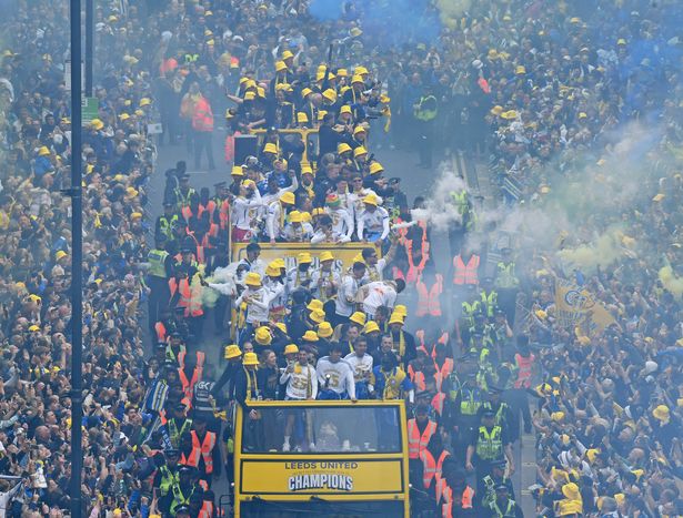Leeds United players on the open top buses make their way through City Square