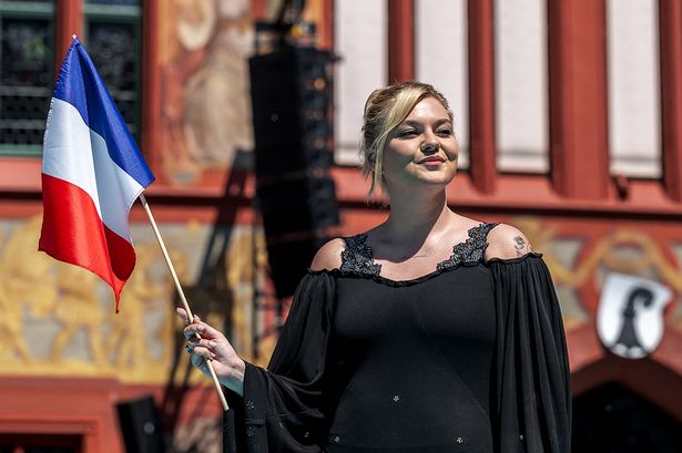French singer Louane holds her national flag as she represents France with the song Maman  