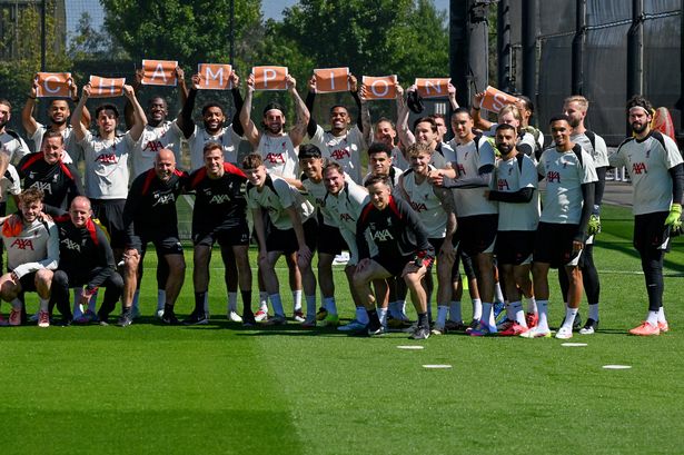 Liverpool players holding up a "Champions" sign for head coach Arne Slot during a training at AXA Training Centre on May 16 2025
