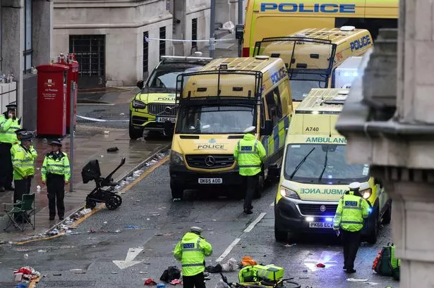 Police officers investigate the scene of an incident in Water Street