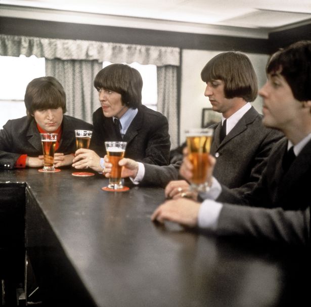 The Beatles drink a beer in a still from their movie 'Help!' which was released in 1965
